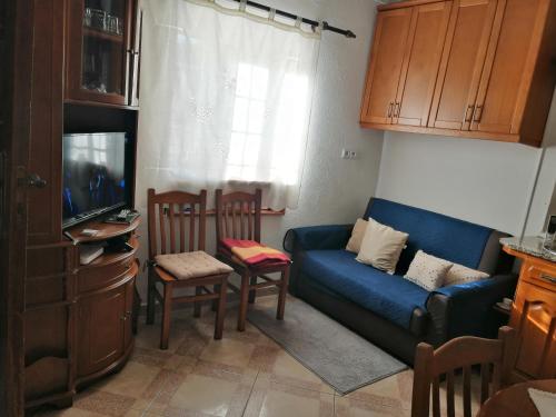 un soggiorno con divano blu e TV di Governo's House a Melo