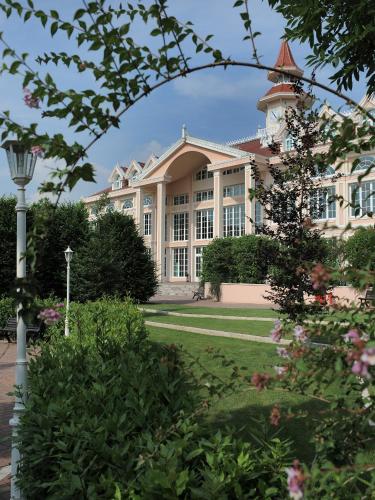 a large white building with a tower at Gardaland Hotel in Castelnuovo del Garda