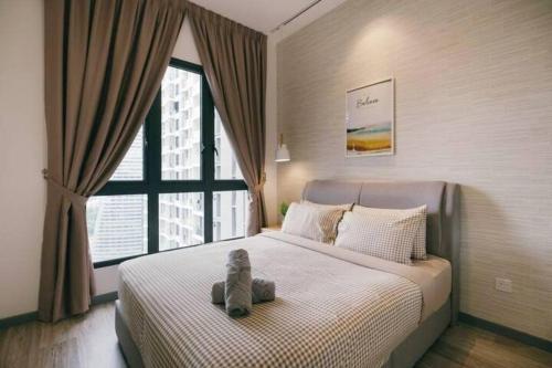 a teddy bear sitting on a bed in a bedroom at Muji Home 2BR 4Pax Southlink Nexus Bangsar South in Kuala Lumpur