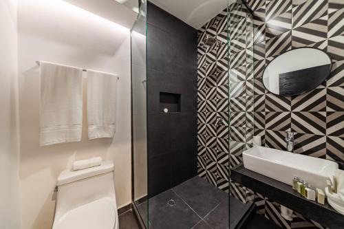 a bathroom with a toilet and a sink and a mirror at Casa Nou in Mexico City