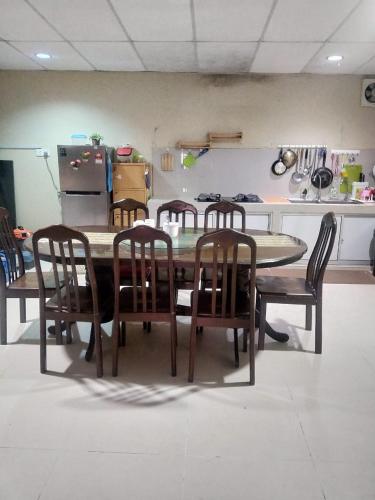 a dining room table with chairs and a kitchen at Beaufort Paguyut Homestay in Beaufort