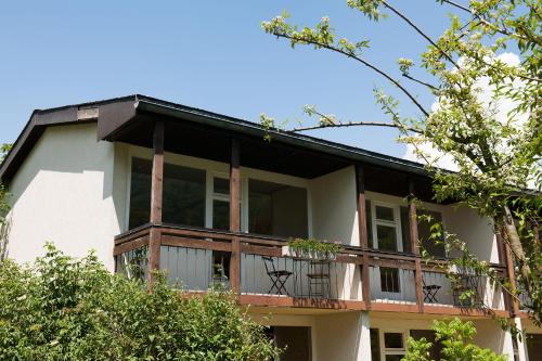 a large white building with a balcony at Jungfrau Hotel Annex Alpine-Inn in Wilderswil