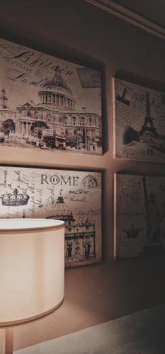 ローマにあるHouse Colosseoの壁画とランプが飾られた部屋