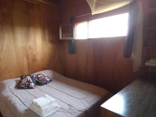 a small bed in a room with a window at La Casita del Puente in La Pedrera