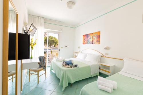 um quarto de hotel com duas camas e uma televisão em Hotel Caprice - in centro a Riccione em Riccione