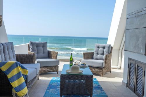 a patio with chairs and a fireplace and the ocean at De Branders Woonstel No 56 & 67 in Hartenbos