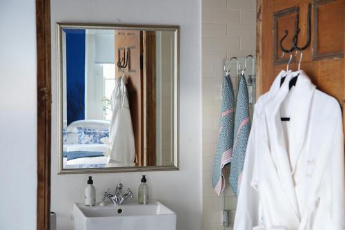 a bathroom with a sink and a mirror at Dennehof Karoo Guesthouse in Prince Albert