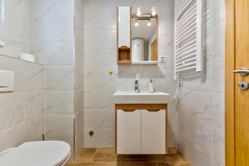 Un baño blanco con lavabo e inodoro. en Apartman Relja Zlatibor, en Zlatibor