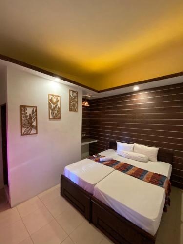 a bedroom with a large bed with a wooden headboard at Watukarung Sackstone Guesthouse in Kalak