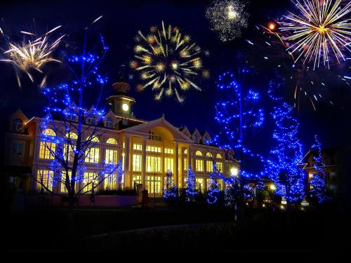 a building with blue lights in front of it with fireworks at Gardaland Hotel in Castelnuovo del Garda