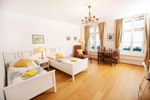 - une chambre avec 2 lits, une table et des chaises dans l'établissement Residenz am Tabor, à Vienne