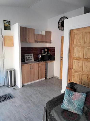 - un salon avec une cuisine dotée d'un canapé et d'une porte dans l'établissement L'ANNEXE endroit zen et chaleureux. Jacuzzi extérieur, à Brignoles