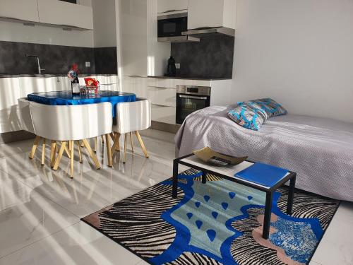 Una habitación con una cama y una mesa y una cocina. en Villa HARMONY, en Vallauris