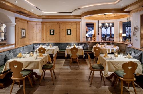 a restaurant with tables and chairs in a room at Gut Sonnberghof in Mittersill