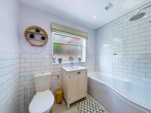 a bathroom with a toilet and a tub and a sink at Broadstairs Beach Bungalow. Dogs welcome! in Broadstairs