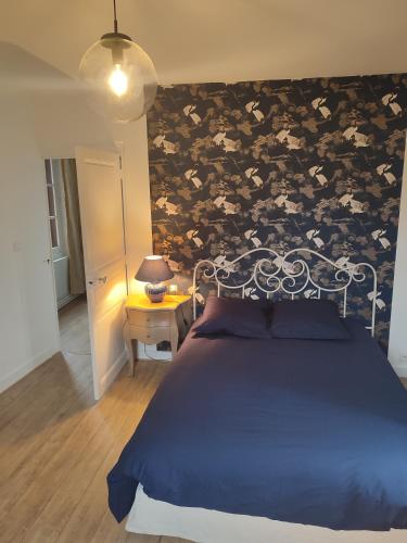 ein Schlafzimmer mit einem blauen Bett und einer Blumenwand in der Unterkunft la tour carrée d'un chateau in Auzouer-en-Touraine