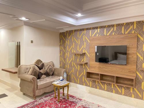 a living room with a couch and a flat screen tv at Arya Hotel Islamabad in Islamabad
