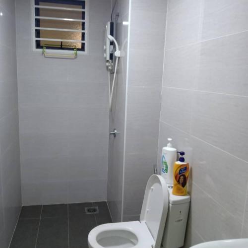 een witte badkamer met een toilet en een wastafel bij Intan in Shah Alam