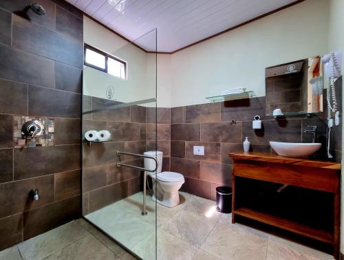 a bathroom with a sink and a toilet and a glass shower at Calathea Lodge Monteverde in Monteverde Costa Rica