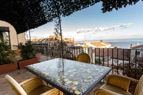 una mesa en un balcón con vistas al océano en Raciti Palace, en Acireale