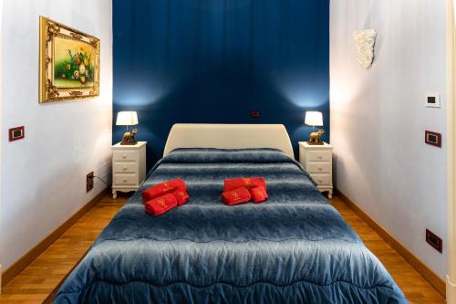 a blue bedroom with a bed with red pillows at Raciti Palace in Acireale