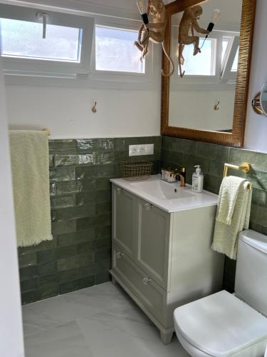 a bathroom with a sink and a toilet and a mirror at Las Palmas in Marbella