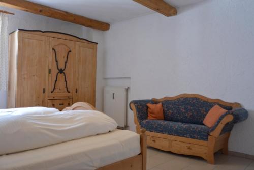 a bedroom with a bed and a blue chair at Ferienhof Mühlthal in Edling