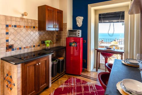 una cucina con frigorifero rosso e tavolo di Raciti Palace ad Acireale