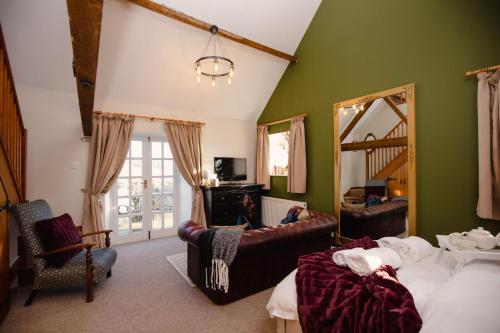 ein Schlafzimmer mit grünen Wänden und Möbeln sowie einem Spiegel in der Unterkunft Hayloft Cottage - Rudge Farm Cottages in Bridport