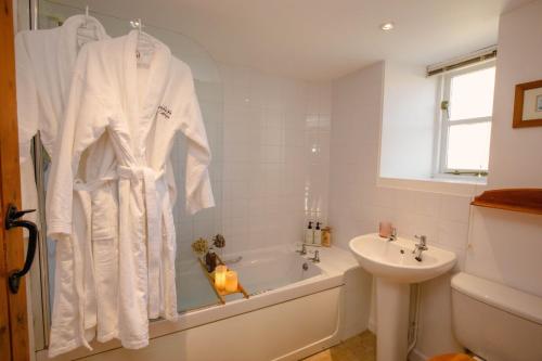 a bathroom with a bath tub and a sink at Hayloft Cottage - Rudge Farm Cottages in Bridport