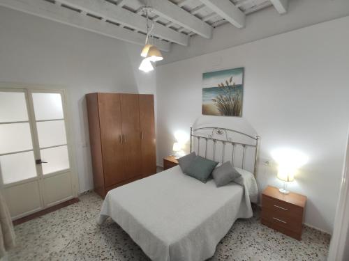 ベヘール・デ・ラ・フロンテーラにあるCasa Mari Carmen, La Plazoletaのベッドルーム1室(ベッド1台、ランプ2つ、窓付)