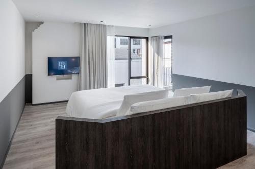 a bedroom with a large bed and a tv at Lilit Bang Lumphu Hotel in Bangkok