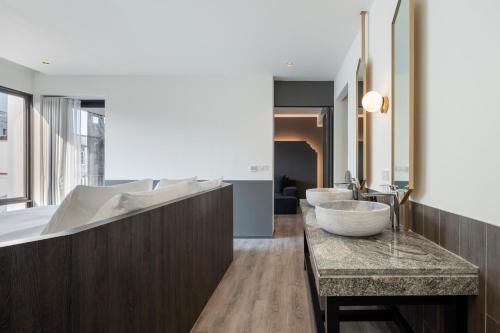 a bathroom with a large tub and a sink at Lilit Bang Lumphu Hotel in Bangkok