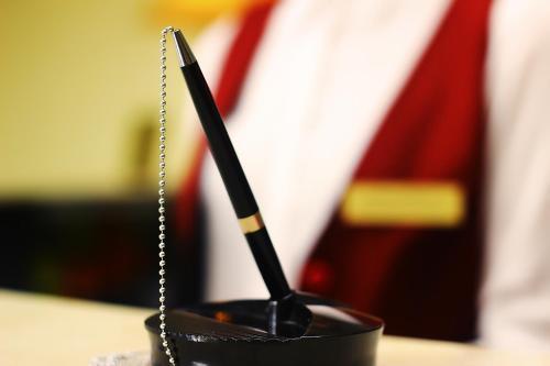 a black holder with a pen and a purse at Hotel Shine Palace in Tbilisi City