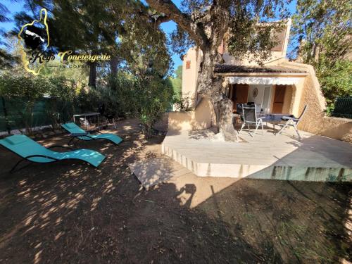 un patio avec des chaises et un arbre en face d'une maison dans l'établissement T3 Classée 3 étoiles proche plage à pied San Cipriano, à San Ciprianu