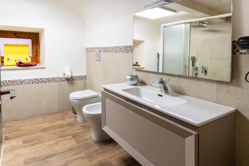 a bathroom with a sink and a toilet and a mirror at Raciti Palace in Acireale