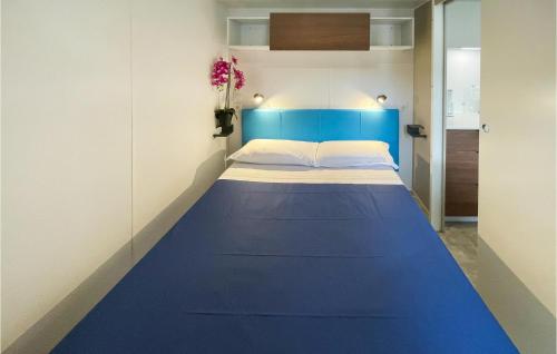 uma cama num pequeno quarto com uma cabeceira azul em Nice stacaravan In Tuoro Sul Trasimeno With Kitchen em Tuoro sul Trasimeno