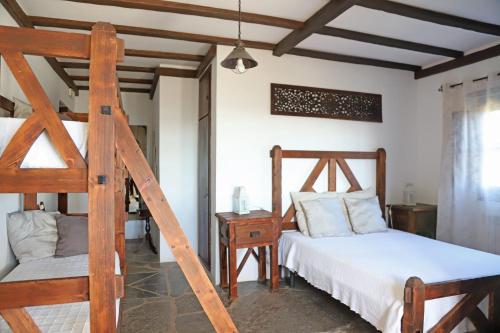 a bedroom with two bunk beds and a chair at Monte Do Caneiro in Mourão