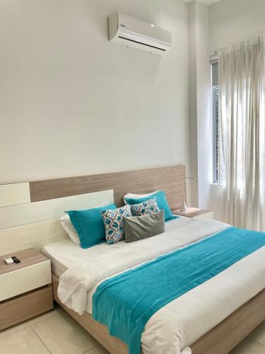 1 dormitorio con 1 cama grande con almohadas azules en Apartamentos Loft Mikonos, en Pereira