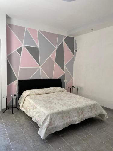 una camera con un letto con una parete rosa e grigia di Dbe apartment LA SIRENA a Francavilla al Mare
