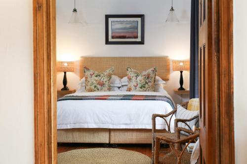 a bedroom with a bed and a mirror at Dennehof Karoo Guesthouse in Prince Albert