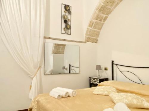 a bedroom with two beds with towels and a mirror at Corte Merlata Apartments in Galatone