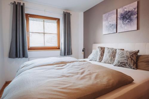 a bedroom with a large white bed and a window at Appartement Stern Dagmar in Neustift im Stubaital