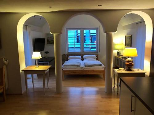 a bedroom with a bed and two tables and a window at Superschöne Ferienwohnungen! in Buxheim