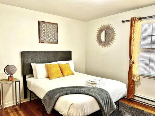 1 dormitorio con cama con almohadas amarillas y espejo en Triple Crown-Casino/Shopping/Brewery/Hampton University/ Langley AFB, en Portsmouth