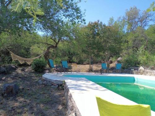 una piscina con sillas y una hamaca en un patio en Finca El Pacará en Agua de Oro