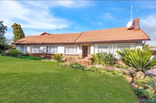a house with a green lawn in front of it at Revive Haven Guesthouse in Roodepoort