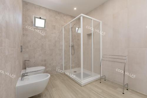 a bathroom with a shower and a toilet and a sink at Villa Alfazema - heatable pool in Albufeira