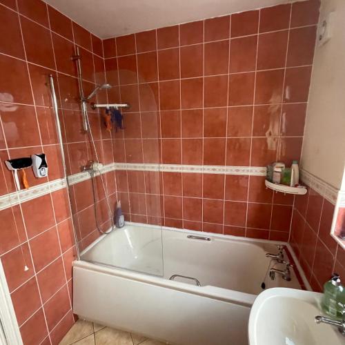 a bathroom with a bath tub and a sink at Spacious Double Room in Leicester