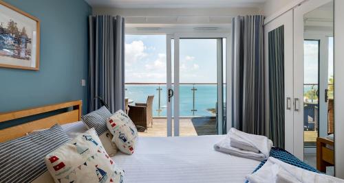 a bedroom with a bed with a view of the ocean at Osprey 2 - The Cove in Brixham